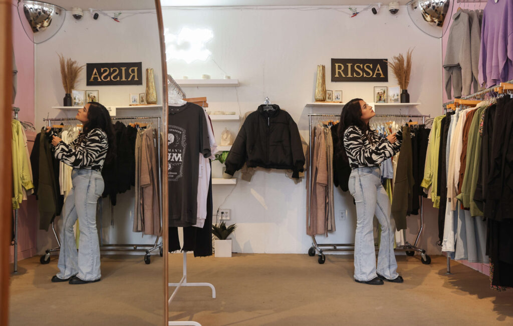 Store owner Mercedes Hernandez looks for clothing to display at Bow N Arrow & Friends in Cotati on Friday, October 28, 2022. (Christopher Chung/The Press Democrat)
