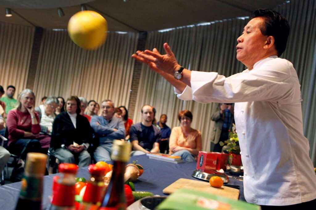 Chinese chef Martin Yan tosses a pomelo, a citrus fruit native to Southeast Asia, into the crowd during a cooking demonstration at the Sonoma County Public Library in Santa Rosa, California on Sunday, February 6, 2011. (BETH SCHLANKER/ The Press Democrat)