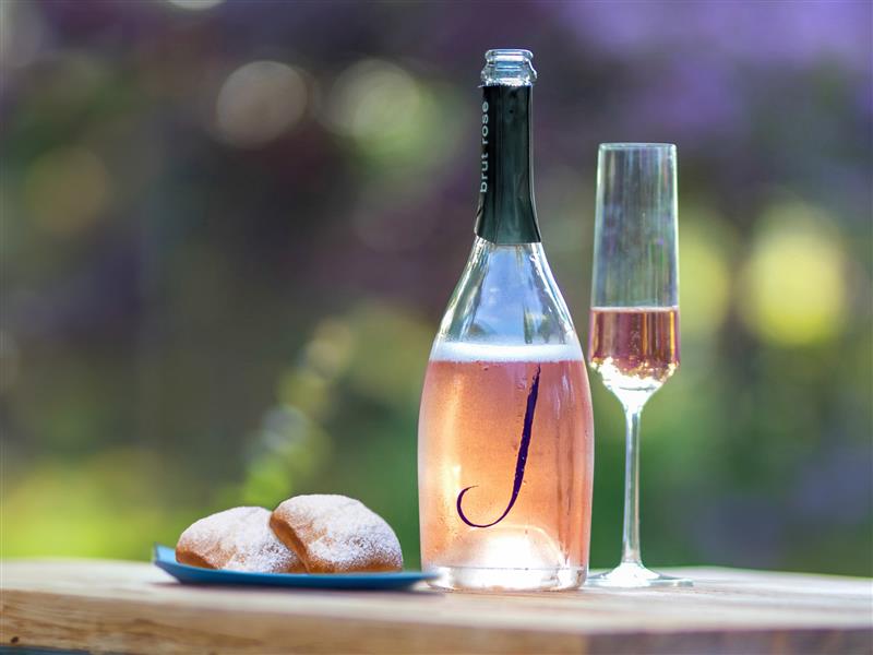 A bottle of J sparkling wine and a plate of beignets