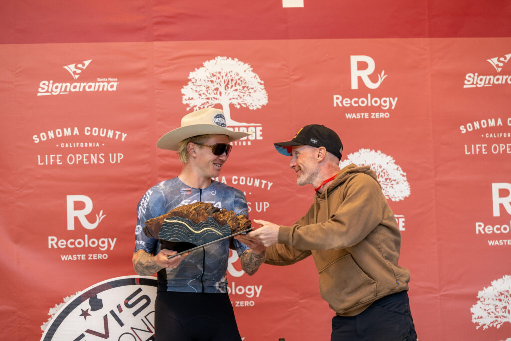 Keegan Swenson, 2025 winner in the men's division of The Growler, a race within Levi’s GranFondo, receives the Rappensperger-designed burl and brass trophy. (Jenny Keller Photography)