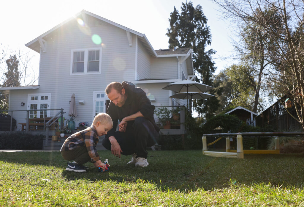 Jake Messing plays with 2-year-old Leo in the backyard of their Healdsburg home on Friday, February 6, 2026. (Christopher Chung/The Press Democrat)