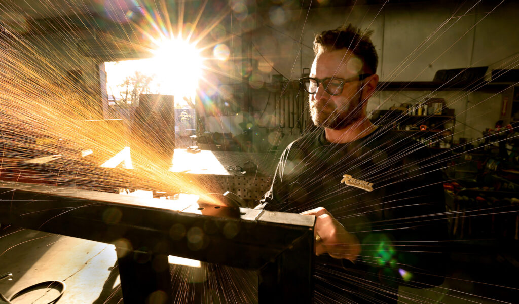Klaus Rappensperger smooths out an edge on a custom metal project at Schnitzkraft Steel Artistry in Santa Rosa, Thursday, Jan. 29, 2026. (Kent Porter / The Press Democrat)
