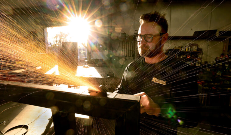 Klaus Rappensperger smooths out an edge on a custom metal project at Schnitzkraft Steel Artistry in Santa Rosa, Thursday, Jan. 29, 2026. (Kent Porter / The Press Democrat)