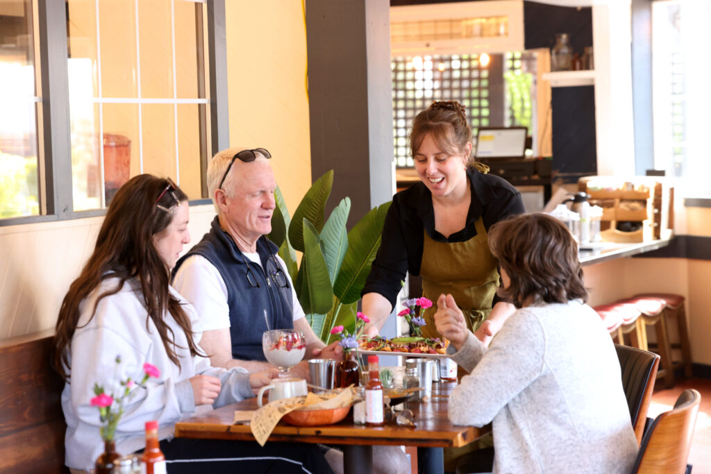Owner Hayley Cutri delivers food to a table at Parkside Eats in Santa Rosa Monday, April 13, 2026. (Beth Schlanker / The Press Democrat)