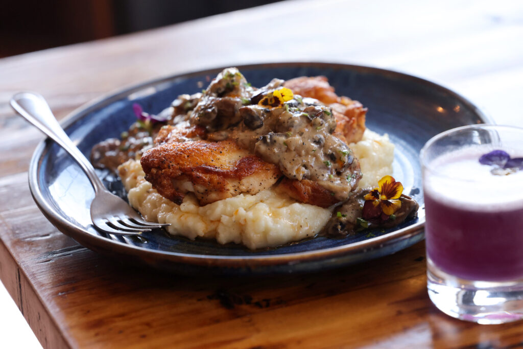 Pan-roasted rosemary chicken over garlic mashed potatoes and topped with mushroom gravy with a Social Butterfly cocktail at Parkside Eats in Santa Rosa Monday, April 13, 2026. (Beth Schlanker / The Press Democrat)