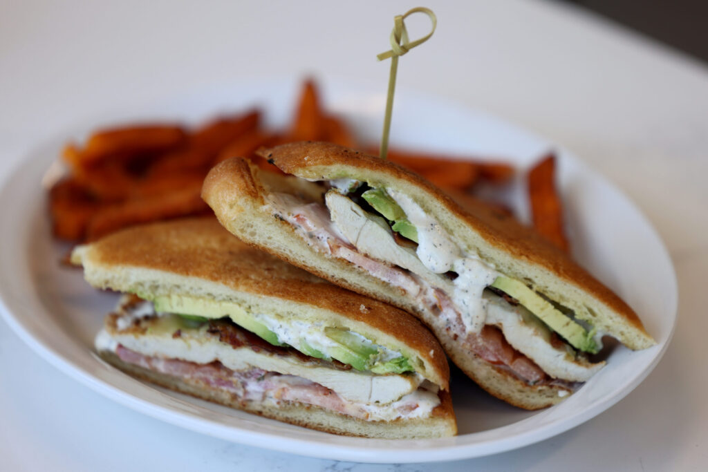 The Chicken Ranch sandwich made with marinated chicken, bacon, avocado, pepper jack cheese, tomato and house-made ranch on a ciabatta bun, with a side of sweet potato fries at Pressed in Rohnert Park Friday, April 17, 2026. (Beth Schlanker / The Press Democrat)