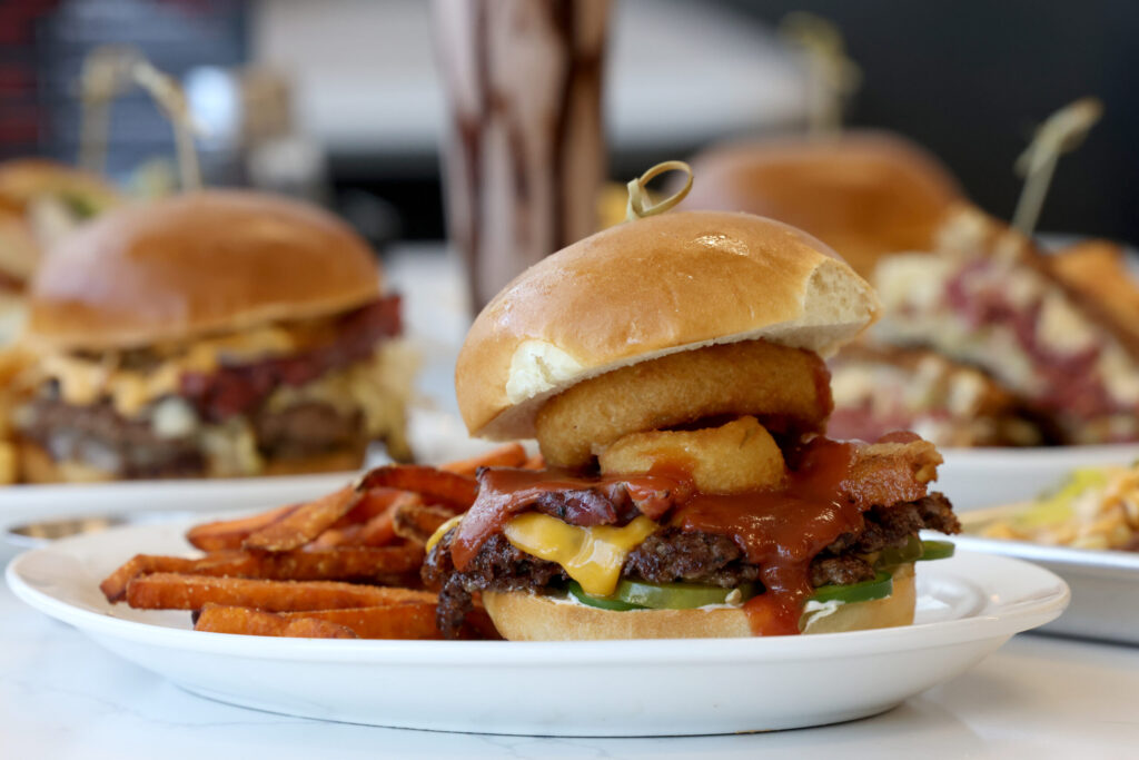 The BBQ Burger, made with two beef patties, onion rings, bacon, jalapeno, pickles, cheddar cheese, barbecue sauce and mayo, with a side of sweet potato fries at Pressed in Rohnert Park Friday, April 17, 2026. (Beth Schlanker / The Press Democrat)