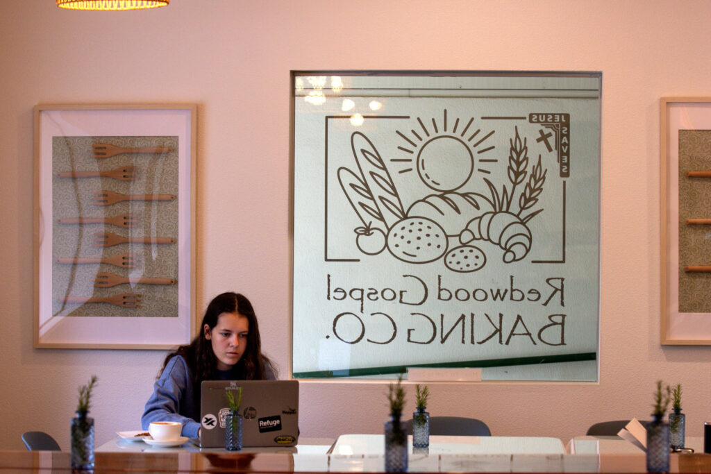 Customer Abby Fisher, of Santa Rosa, enjoys coffee as she works on her computer in the dining room at the new Redwood Gospel Baking Company cafe in Santa Rosa, Friday, April 10, 2026. (Darryl Bush/For The Press Democrat)