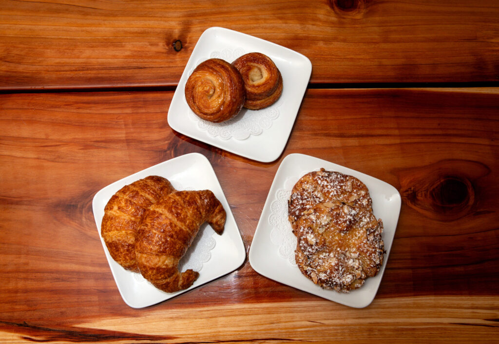 Clockwise, showing a few of the pastries served are: plain croissants, kouign-amann pastries, and almond croissants, at the new Redwood Gospel Baking Company cafe in Santa Rosa, Friday, April 10, 2026. (Darryl Bush/For The Press Democrat)