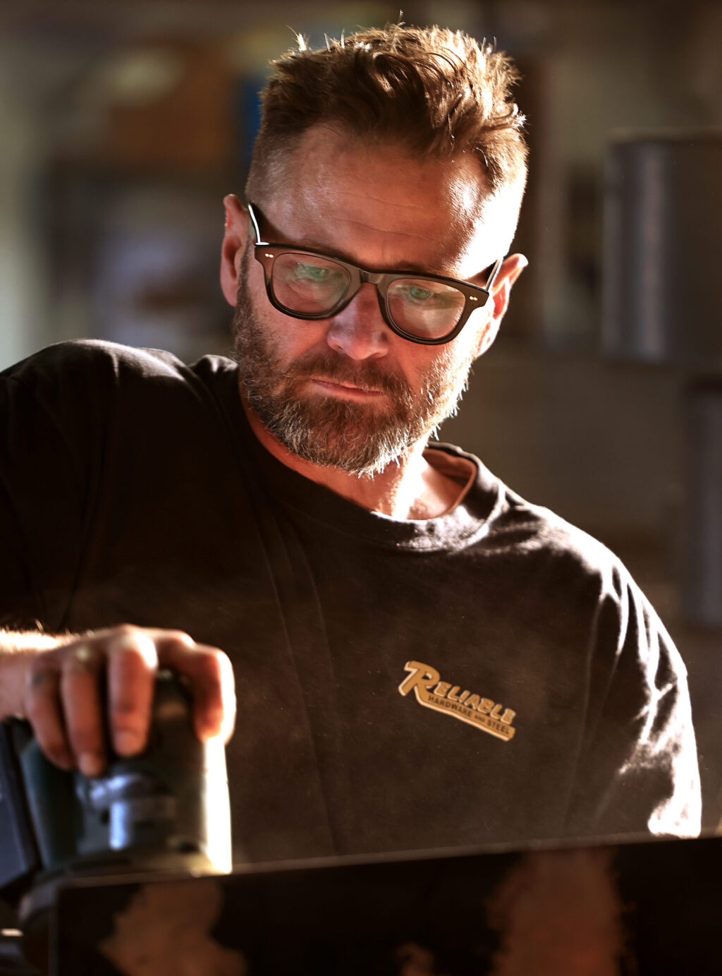 Klaus Rappensperger uses a sander on a custom metal tabletop project at Schnitzkraft Steel Artistry in Santa Rosa, Thursday, Jan. 29, 2026. (Kent Porter / The Press Democrat)