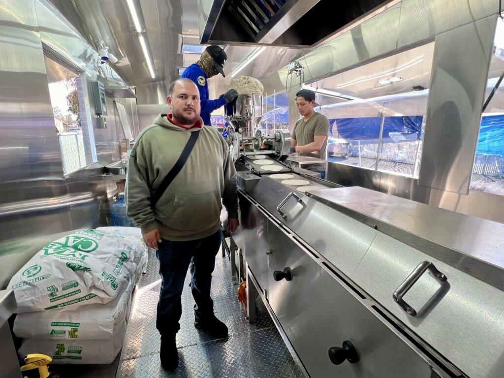 Cristian Alvarez shows how an industrial tortilla machine works, inside of Tortilleria Apatzingan, his tortilla factory on wheels permanently parked on 990 Sebastopol Road, in the Roseland neighborhood, in Santa Rosa, on Jan. 28, 2026. (Raquel Issenberg / La Prensa Sonoma)