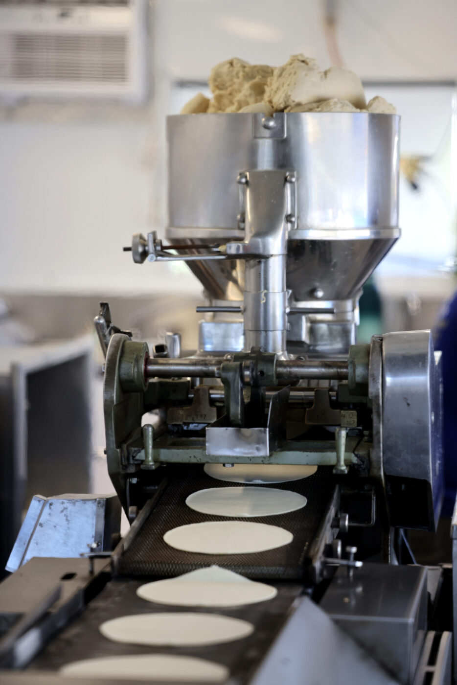 An automated tortilla press operates at Tortilleria Apatzingan in Santa Rosa Tuesday, July 8, 2025. (Beth Schlanker / The Press Democrat)
