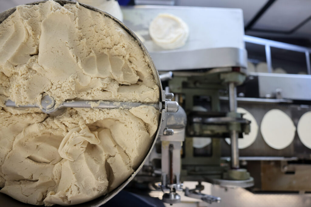A hopper filled with masa feeds into an automated tortilla press at Tortilleria Apatzingan in Santa Rosa Tuesday, July 8, 2025. (Beth Schlanker / The Press Democrat)