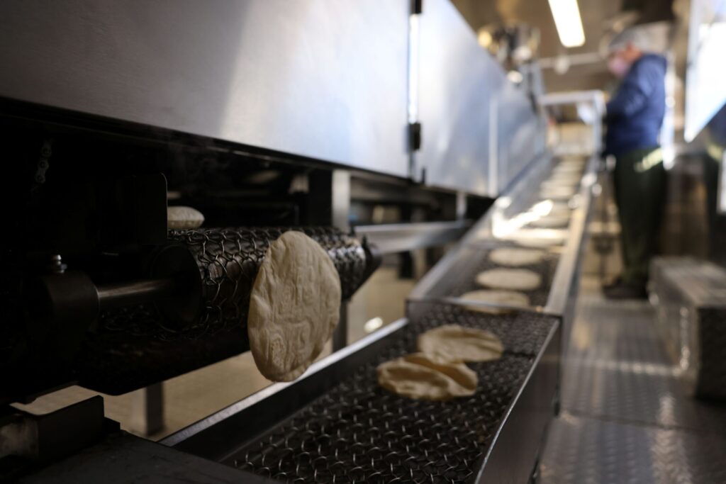 Fresh tortillas come out of the oven of a tortilla machine Tortilleria Mexico Mi Amor in Napa Thursday, Feb. 5, 2026. (Beth Schlanker / The Press Democrat)