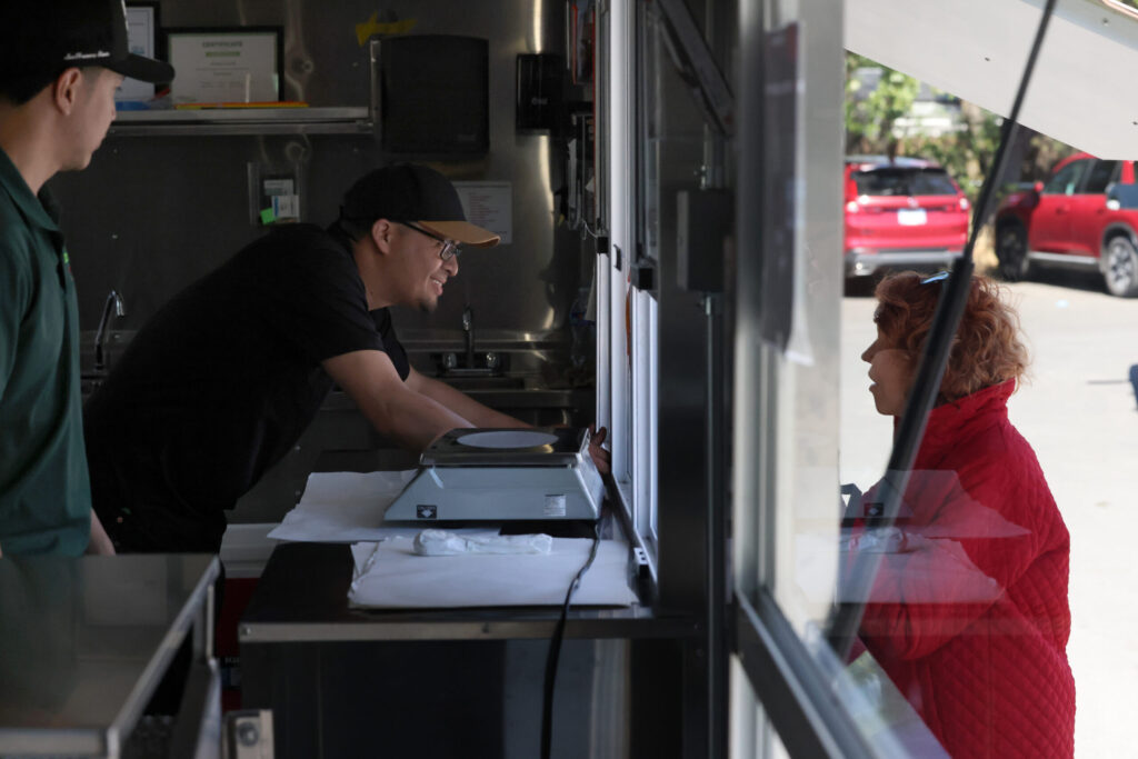 Tortilleria Ortuno owners Elias Garduno, left, and his brother-in-law Jorge Cuiriz, center, talk with a customer in Sonoma Monday, April 6, 2026. (Beth Schlanker / The Press Democrat)