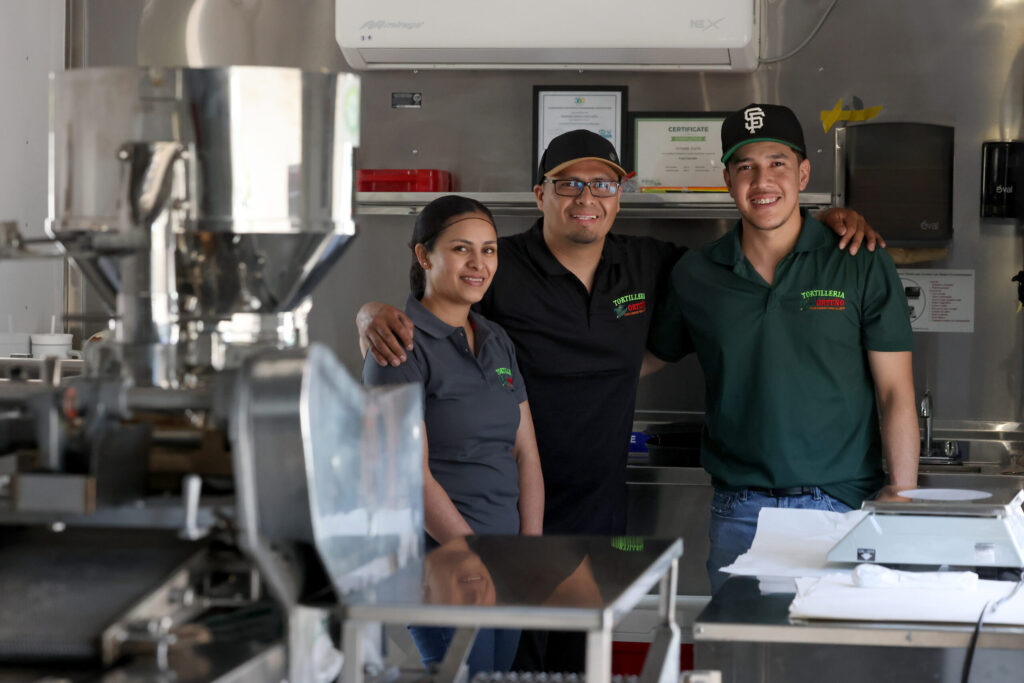 Tortilleria Ortuno owners Maribel Cuiriz, left, her brother Jorge Cuiriz, center, and her husband Elias Garduno, right, inside the mobile tortilleria in Sonoma Monday, April 6, 2026. (Beth Schlanker / The Press Democrat)