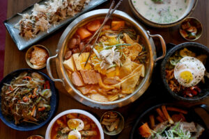 Army Stew, center, surrounded by a variety of dishes at Seoul to Tokyo restaurant in Santa Rosa Monday, May 4, 2026. (Beth Schlanker / The Press Democrat)