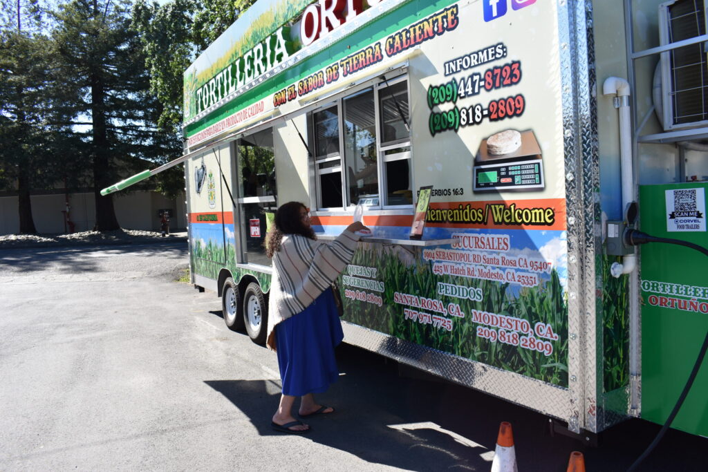 Maria Settles, a Sonoma resident, buys fresh corn tortillas from mobile tortilla factory "Tortilleria Ortuño", a food truck parked behind Sonoma Valley Fruit Basket at 18474 Sonoma Highway. Friday, April 3, 2026, in Sonoma. (Raquel Issenberg / La Prensa Sonoma)