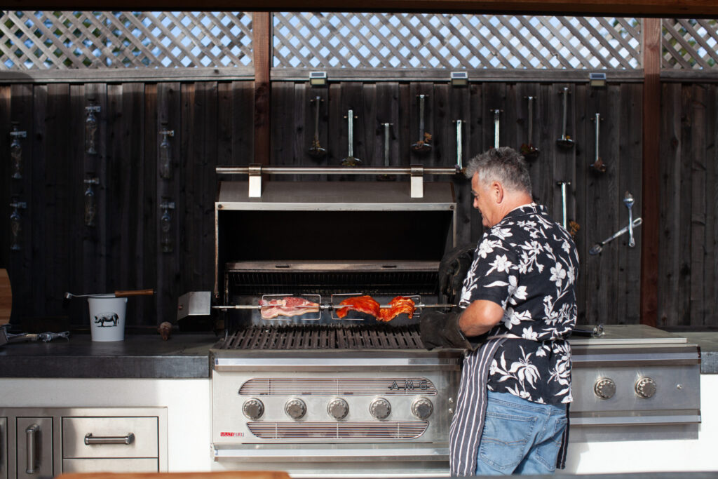 Josh Silvers prepares a barbecue feast in his backyard, the setting for many gatherings with family and friends. (Eileen Roche)