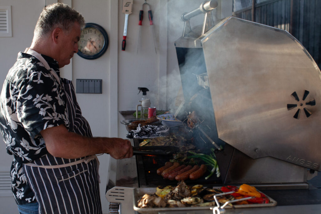 Josh Silvers prepares a barbecue feast in his backyard, the setting for many gatherings with family and friends. (Eileen Roche)