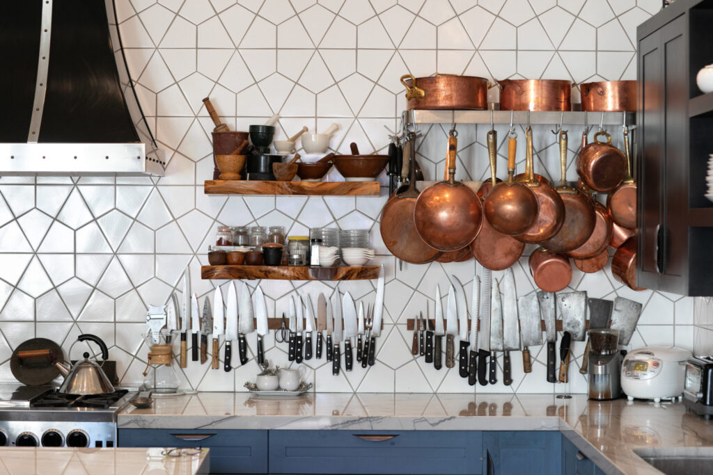 Josh Silvers’ prized collection of copper pots and knives, including the first knife he ever used professionally. The Silverses are inveterate collectors. (Eileen Roche)