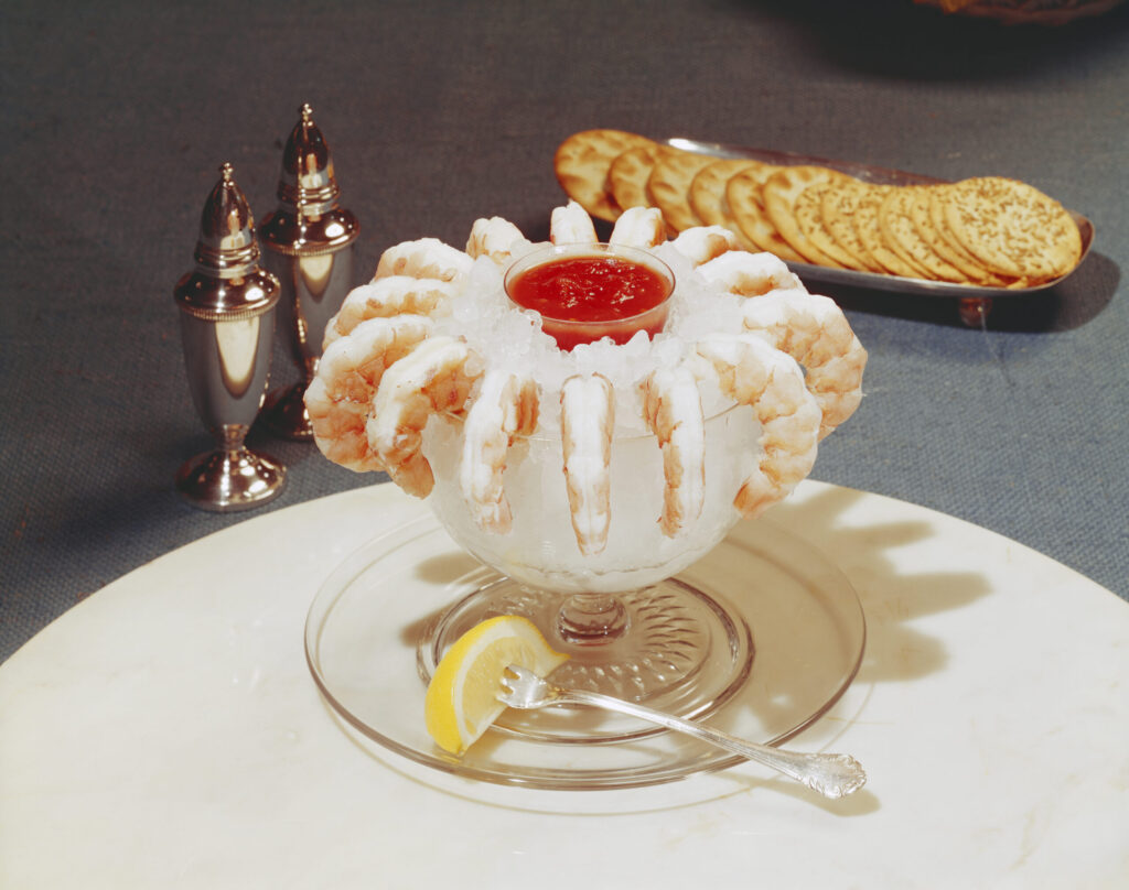 Prawns/shrimp decorated with crushed ice and cocktail sauce
