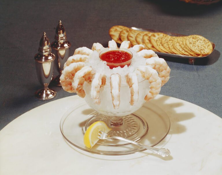 Prawns/shrimp decorated with crushed ice and cocktail sauce