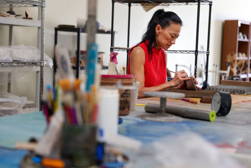 Jee Park, of Seoul Sister Studio, works on etching a clay bowl at her studio in Healdsburg on Thursday, March 19, 2026. (Christopher Chung/The Press Democrat)