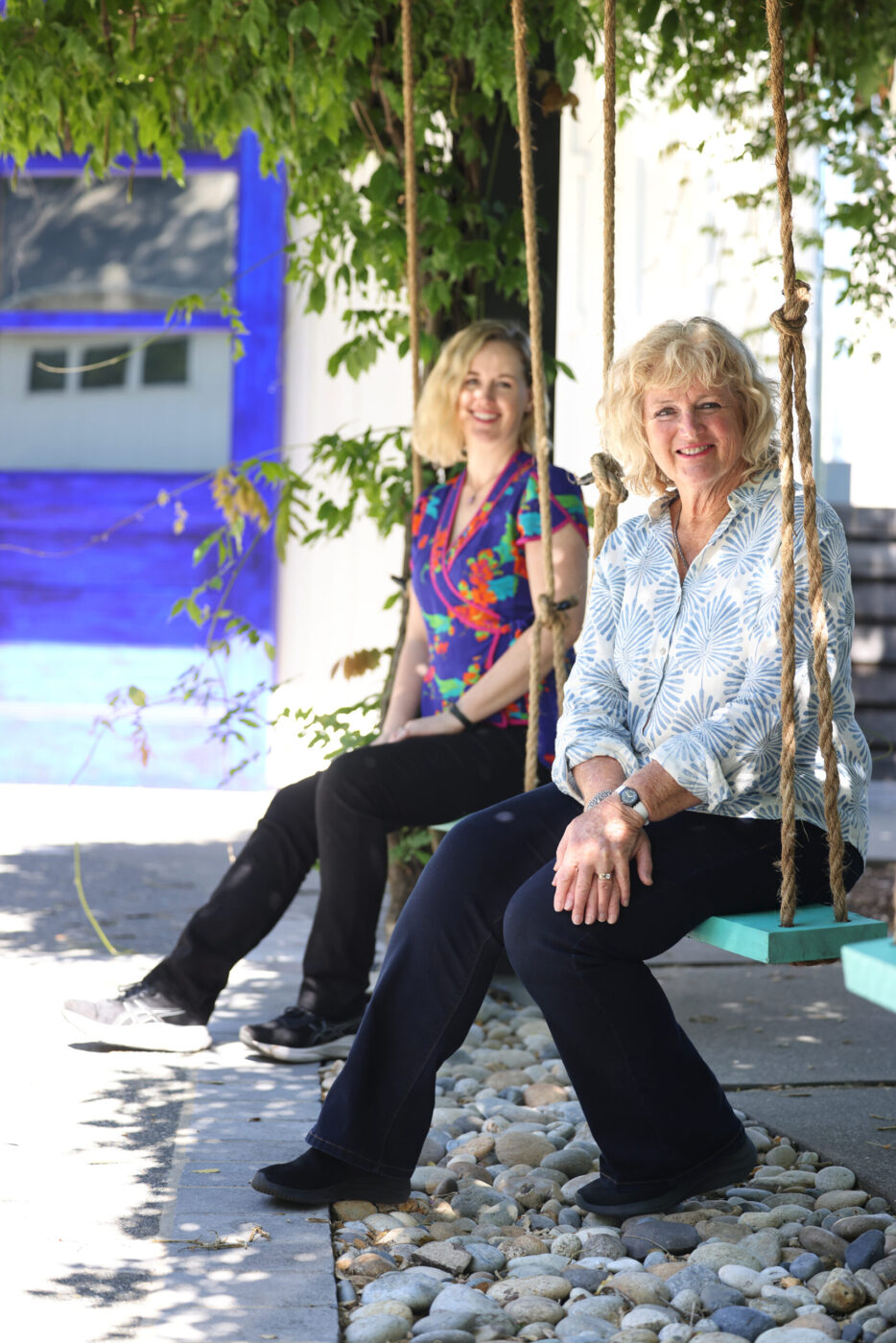 Heidi Peterson Barrett and her daughter Remi sit on swings outside La Sirena tasting room in Calistoga Wednesday, May 13, 2026. (Beth Schlanker / The Press Democrat)