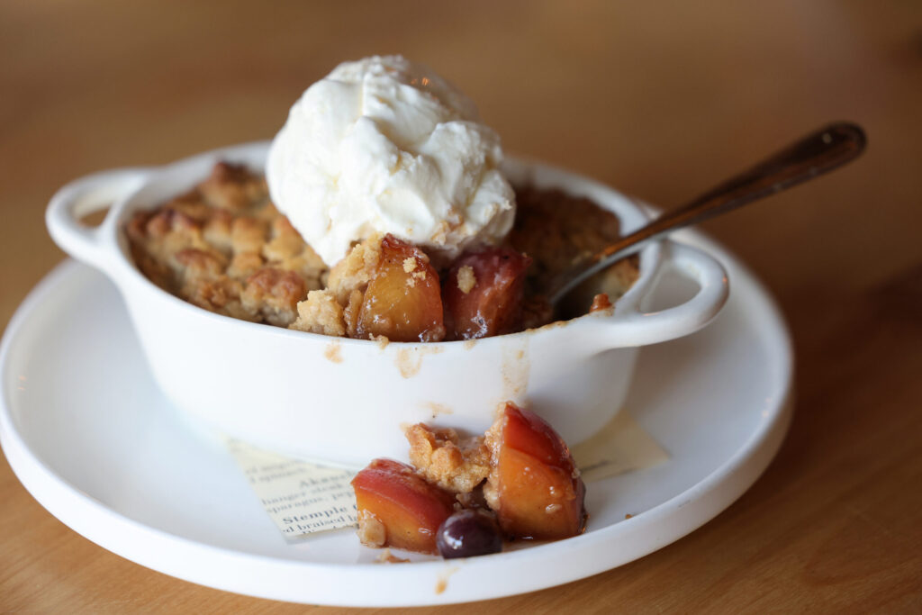 The peach and blueberry crumble with vanilla ice cream at Seared in Petaluma Thursday, June 18, 2026. (Beth Schlanker / The Press Democrat)