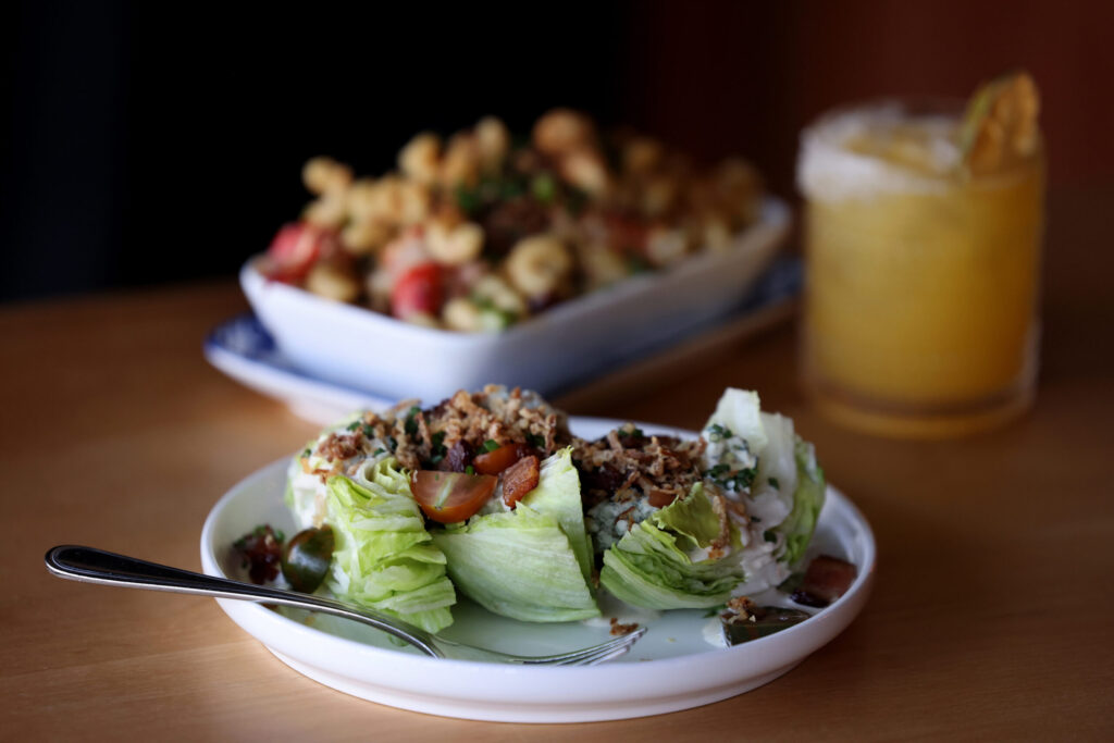 The Wedge salad, Lobster Mac n’ Cheese, and the Bon Vivant cocktail at Seared in Petaluma Thursday, June 18, 2026. (Beth Schlanker / The Press Democrat)