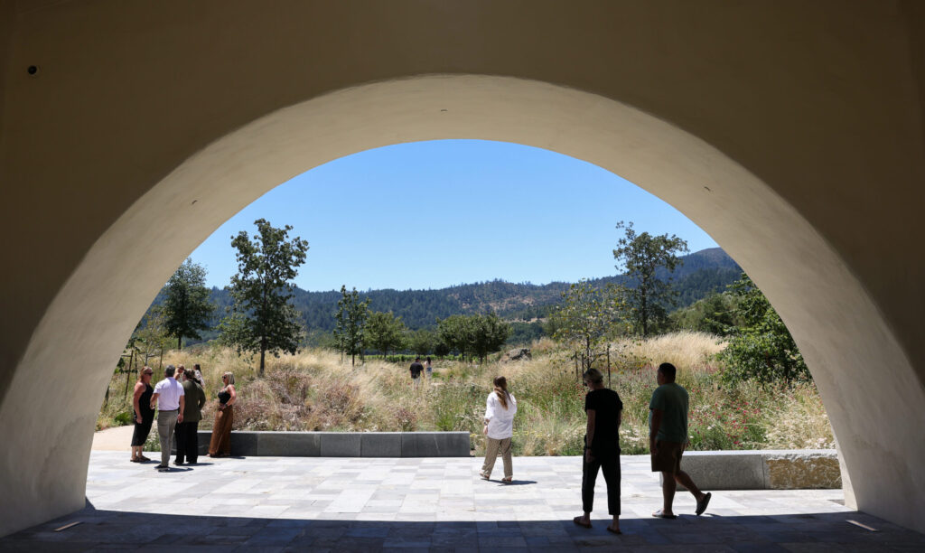 Guests make their way through the archway leading to the garden at Robert Mondavi Winery in Oakville on Wednesday, June 24, 2026. (Christopher Chung/The Press Democrat)