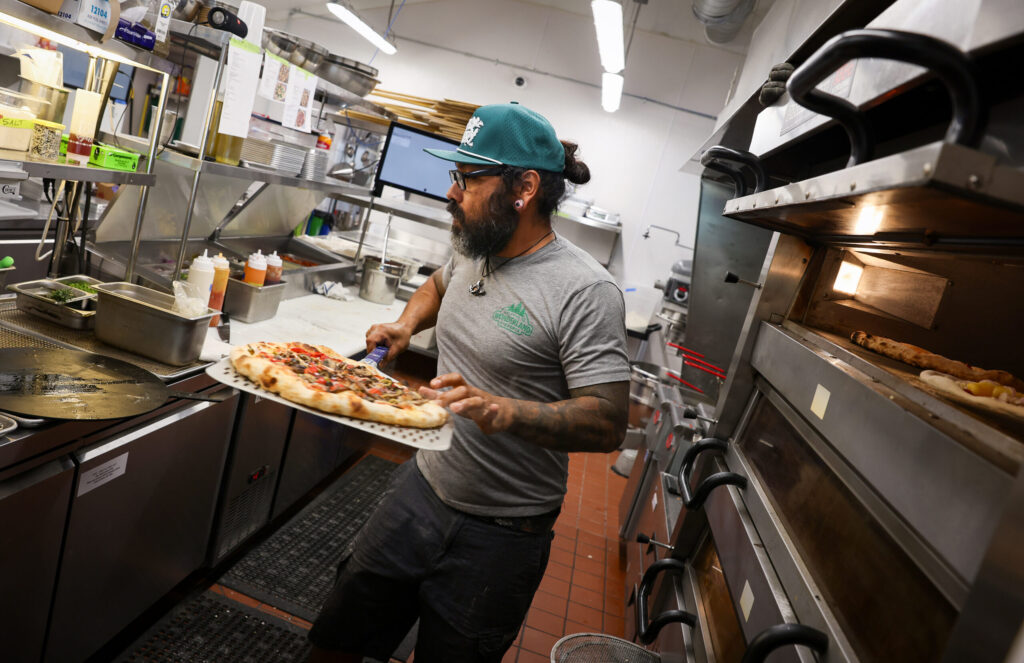 Nacho Sanchez pulls a pizza from the oven at Wonderland Pizzeria in Monte Rio on Wednesday, June 17, 2026. (Christopher Chung/The Press Democrat)