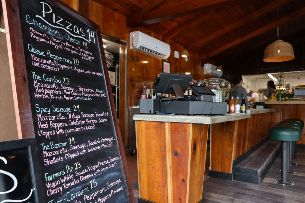 The menu at the entrance of Wonderland Pizzeria in Monte Rio on Wednesday, June 17, 2026. (Christopher Chung/The Press Democrat)