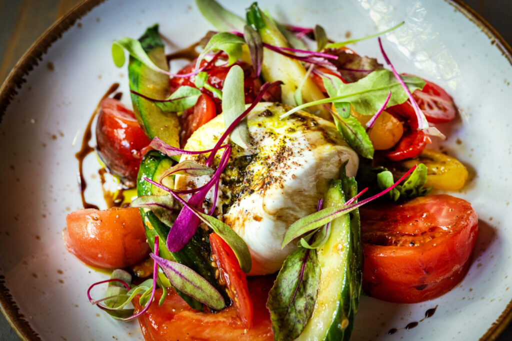 Heirloom Tomato and Burrata with sliced cucumber, balsamic reduction, basil, olive oil and lava salt from Salt & Stone in the heart of the Sonoma Valley Monday, June 1, 2026 in Kenwood. (John Burgess/The Press Democrat)