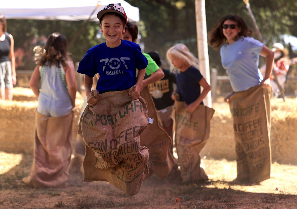 Cooper Pellegrini, 11, from Penngrove enjoys the last days of summer by placing first in his sack racing heat during the Gravenstein Apple Fair in Sebastopol, Saturday, August 9, 2025. (Kent Porter / The Press Democrat)