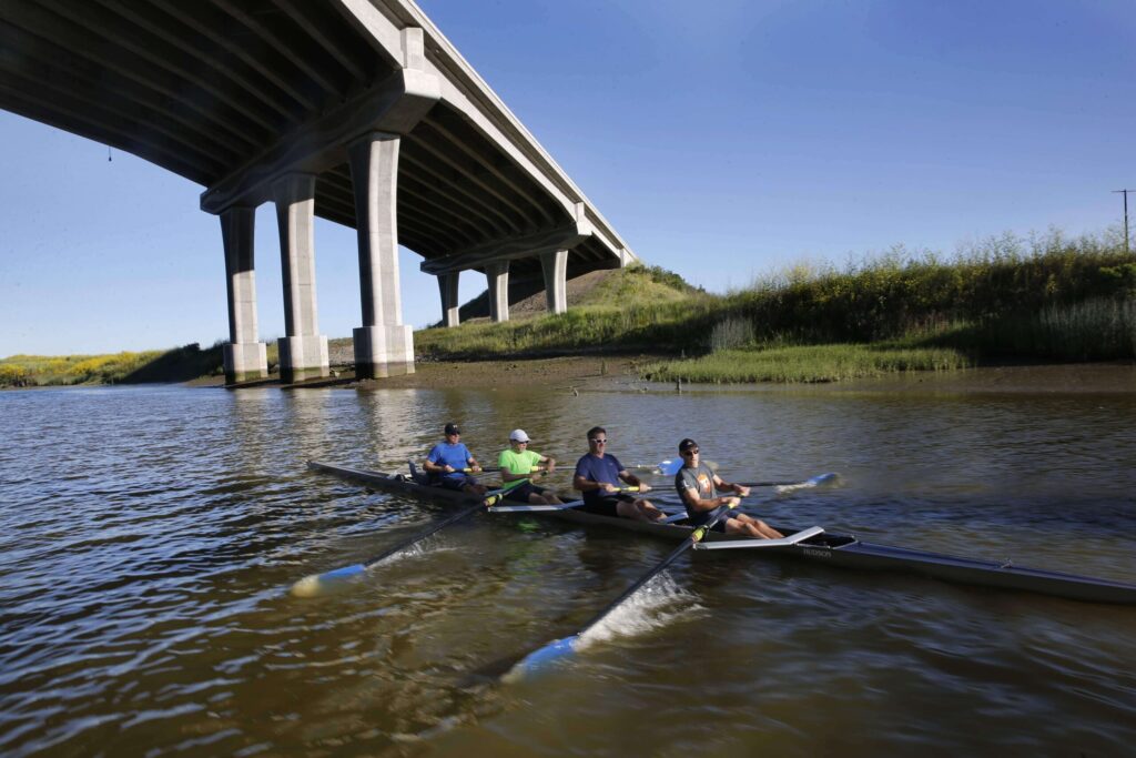 From right to left, members of the North Bay Rowing Club, Steve Skubic, Brendan Galten, Ben Demshe, and Nick Honey take part in an early morning workout on the Petaluma River on Saturday, May 12, 2018, in Petaluma. (Beth Schlanker/The Press Democrat)