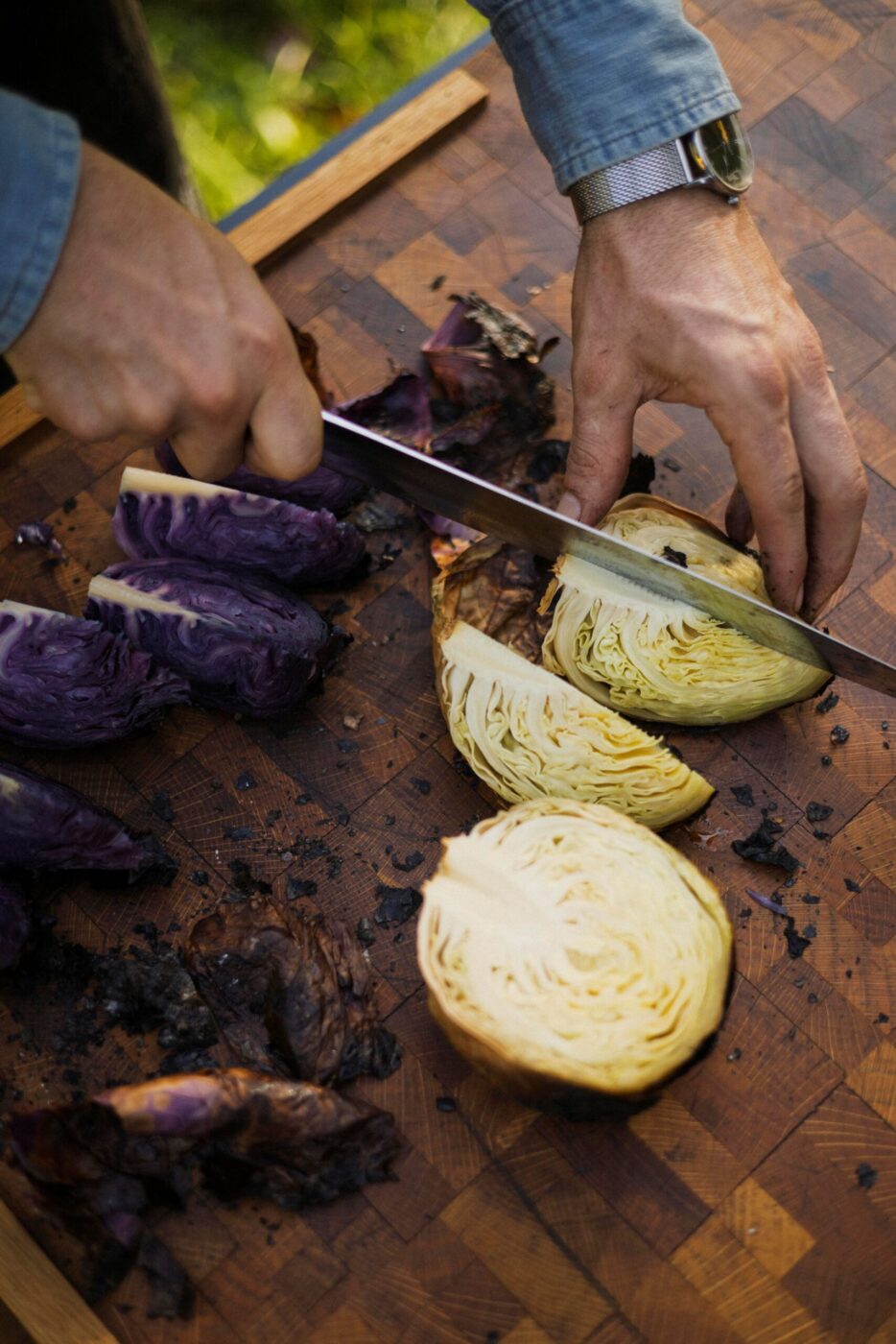 Chef Lee Desrosiers slices cabbage he slow-roasted over hot embers. (Conor Hagen)
