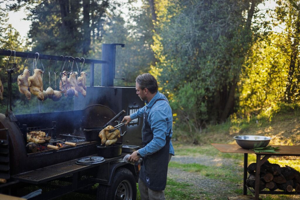 Chef Lee Desrosiers slow-roasts his signature "Hell Chicken" in a converted pig smoker. (Conor Hagen)