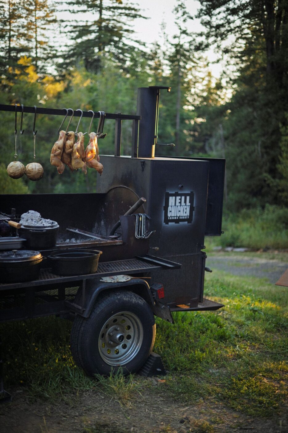 Chef Lee Desrosiers slow-roasts his signature "Hell Chicken" over coals in a converted pig smoker. (Conor Hagen)