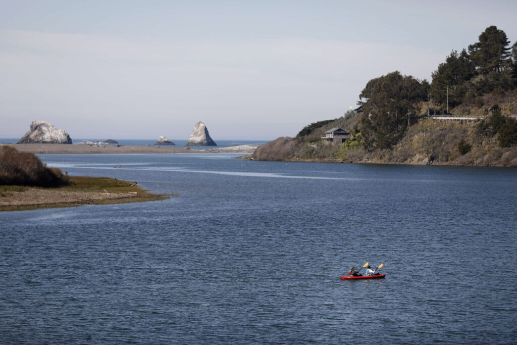 Kayakers, with a rental from WaterTreks EcoTours, cross the Russian River in Jenner, Calif., on Sunday, February 13, 2022.(Beth Schlanker/The Press Democrat)
