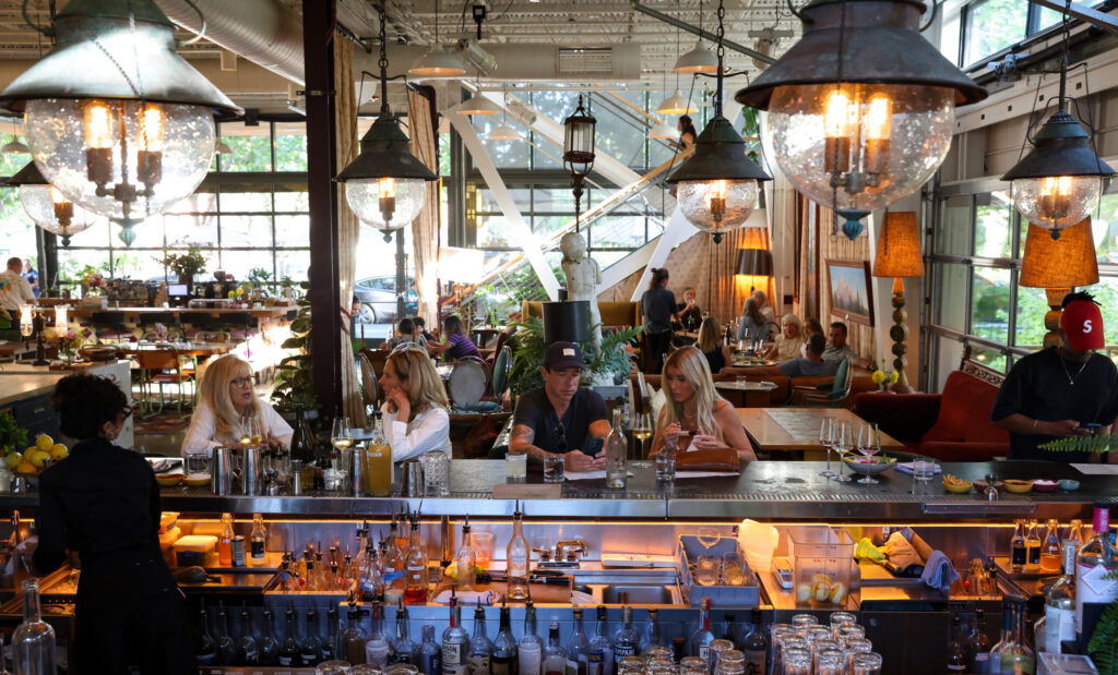 Guests hang out at the bar before the start of a music performance at Little Saint in Healdsburg on Thursday, July 9, 2026. (Christopher Chung/The Press Democrat)