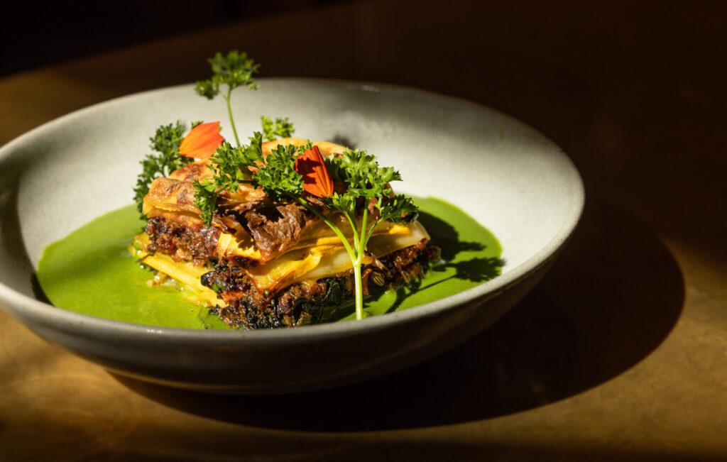 Spinach & Fennel Sausage Lasagna with Caramelized Leeks and bay-Infused Béchamel, cultured cashew mozzarella and spinach salsa from Little Saint in Healdsburg. (John Burgess/The Press Democrat)