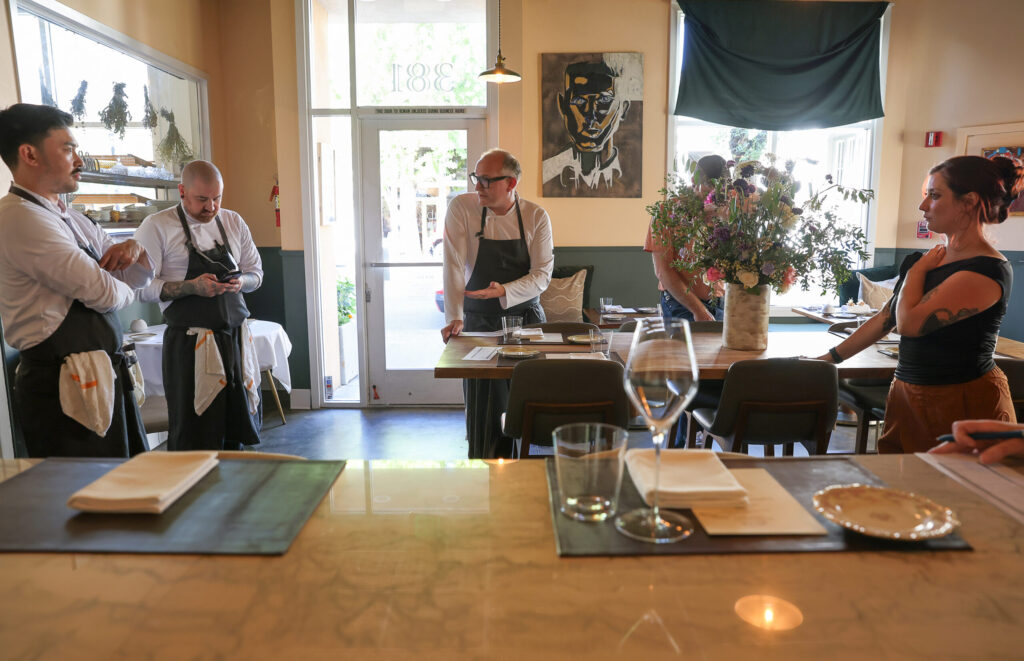 Troubadour Bread & Bistro owner/chef Sean McGaughey, center, meets with his staff before dinner service in Healdsburg on Thursday, July 2, 2026. (Christopher Chung/The Press Democrat)