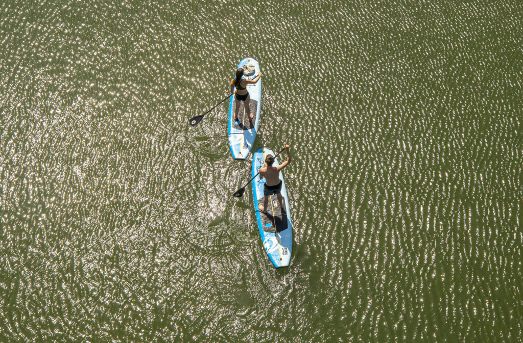 Sage Wild and Amy Melman head down the Russian River on their stand-up paddle boards on Wednesday, April 14, 2021. A very dry dry winter and historically low water levels in Lakes Sonoma and Mendocino will lead to a difficult summer recreation season on the Russian river. (Photo by John Burgess/The Press Democrat)