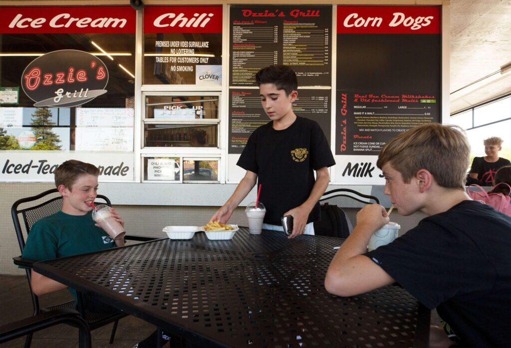 Rincon Valley Middle School classmates Jackson Hunt, left, Jake Spector, and Cooper Buckles enjoy cold drinks and snacks at Ozzie's Grill after completing their first day back to school in Santa Rosa on Wednesday, Aug. 14, 2019. (Alvin Jornada / The Press Democrat)