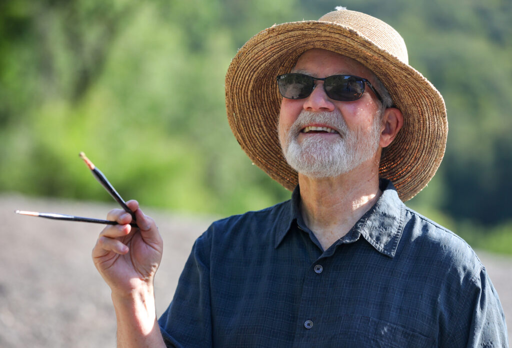 Christopher Leith Evans studies the light and shadows on the trees while painting along the Russian River in Healdsburg on Monday, May 11, 2026. (Christopher Chung/The Press Democrat)