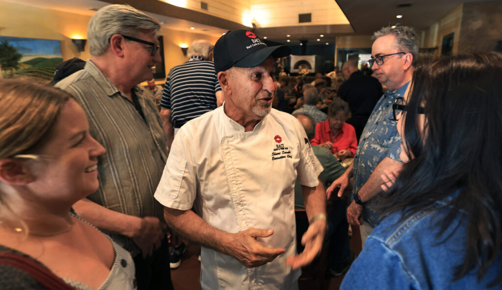 Baci Cafe and Wine Bar chef Shari Sarabi and husband to Lisbeth Holmefjord, greets friends during the reopening of the restaurant, Wednesday, July 29, 2026, after a vehicle slammed through the front of the Healdsburg establishment in May. (Kent Porter / The Press Democrat)