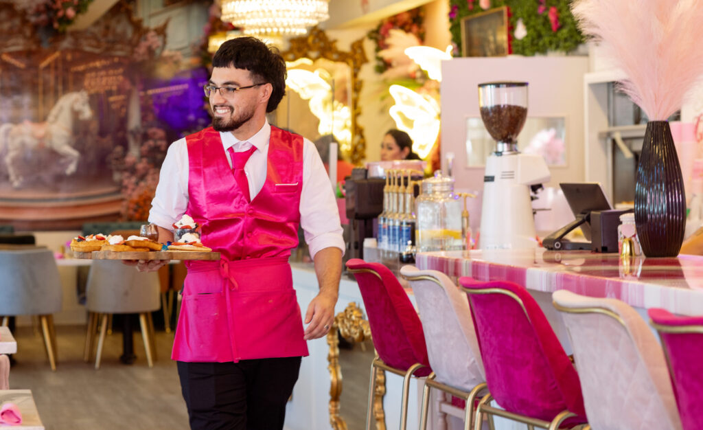 Server Victor Tabares and all the servers don pink outfits at Café Carrusel Tuesday, July 28, 2026 in Santa Rosa. (John Burgess/The Press Democrat)