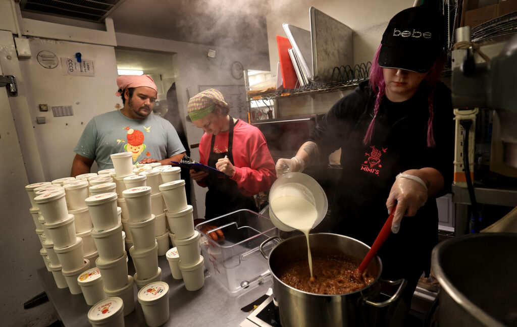 From left, Carter Olson and Oskar Grophe inventory pints of ice cream as Lynsey Rasmussen creates a new flavor, Wednesday August 12, 2026, at Screamin' Mimi's in Sebastopol. (Kent Porter / The Press Democrat)